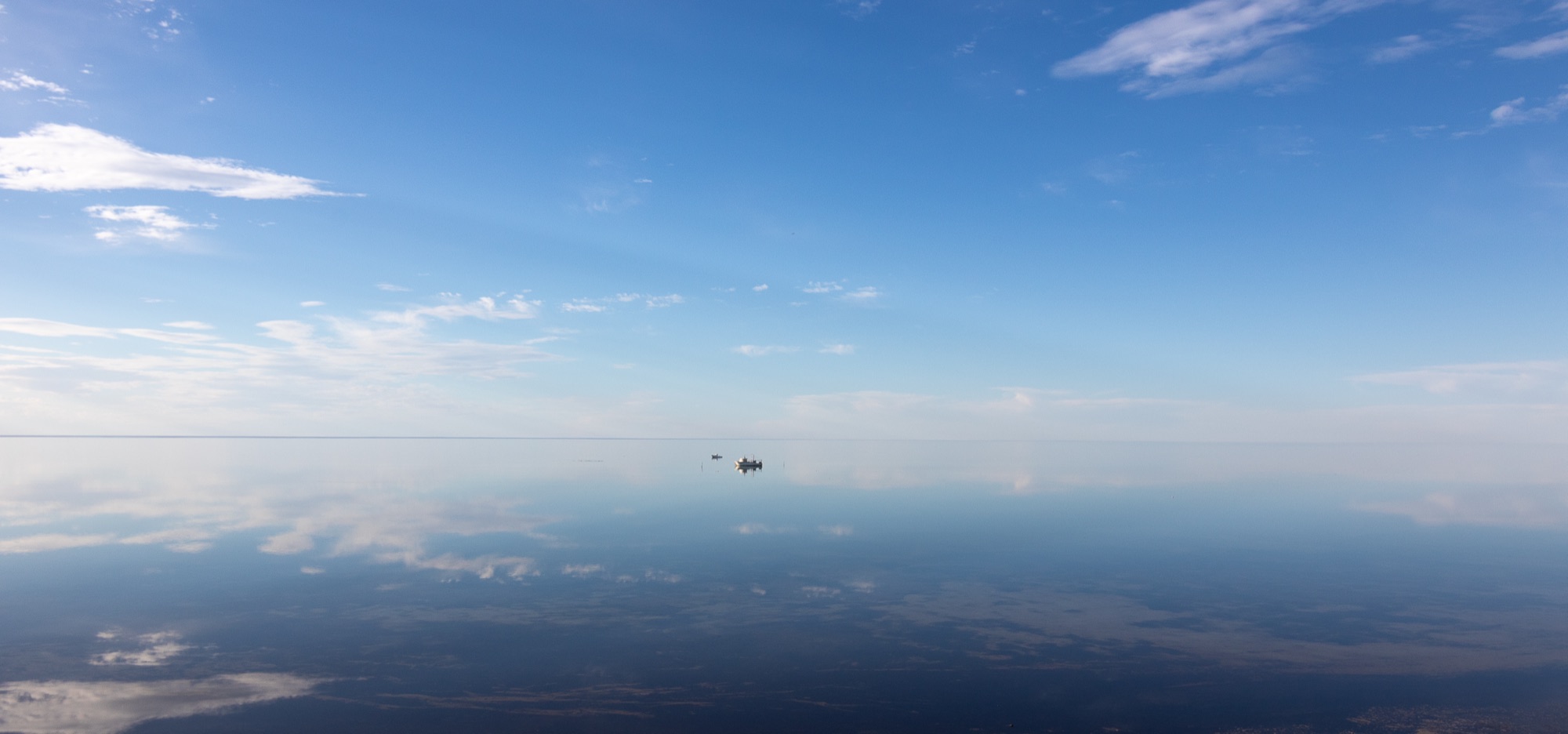 Vastness — a still glassy sea meeting a soft sky.